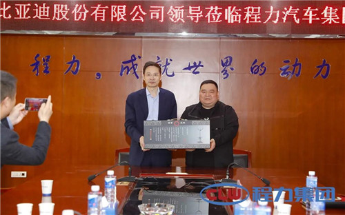 程力汽車集團總經理程阿羅（右）向比亞迪副總裁王杰贈送隨州歷史文化創(chuàng)意禮品----鹿鶴模型　　